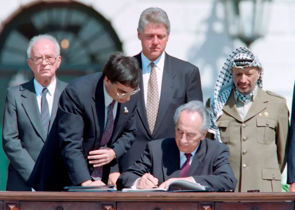 Israeli Foreign Minister Shimon Peres, center, signs the first of the Oslo accords in a ceremony at the White House on Sept. 13, 1993. From left are Israeli Prime Minister Yitzhak Rabin, an unidentified aide, U.S. President Bill Clinton and Palestine Liberation Organization Chairman Yasser Arafat. (J. David Ake/AFP/Getty Images)